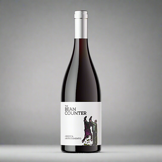 a bottle of red wine with the bean counter written on it. It has a picture of a man being held upside down by his feet and money is falling out of his pockets